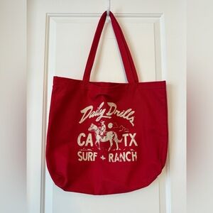 Daily Drills red canvas tote bag featuring a white "SURF + RANCH NEW